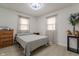 Bright bedroom featuring a ceiling fan, two windows, wood flooring, and grey bedding at 5510 Chelsea Rd, Indianapolis, IN 46241