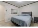 Clean bedroom with modern mirror, grey headboard, and light blue bedding at 5510 Chelsea Rd, Indianapolis, IN 46241