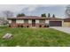 Charming ranch-style home with a well-maintained lawn, brick accents, and attached garage at 5510 Chelsea Rd, Indianapolis, IN 46241