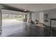 Spacious garage interior with garage door open and painted walls including storage and exercise equipment at 5510 Chelsea Rd, Indianapolis, IN 46241