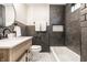 Modern bathroom with dark tile, white countertops, and a shower-tub combination at 5516 S Randolph St, Indianapolis, IN 46227