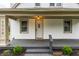 Inviting front entrance featuring a white door, decorative light fixture, and charming landscaping at 5516 S Randolph St, Indianapolis, IN 46227