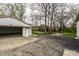Detached one car garage featuring a white door and an expansive driveway at 5516 S Randolph St, Indianapolis, IN 46227