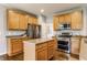 Well-lit kitchen with a center island, stainless steel appliances, and wood cabinets at 559 Hythe Way, Westfield, IN 46074
