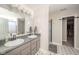 Neutral bathroom featuring a double sink vanity, mirror with lighting, and walk in shower at 5820 Marble Ct, Anderson, IN 46013