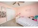 A bright bedroom featuring pink walls, ceiling fan, and a sunny window at 5820 Marble Ct, Anderson, IN 46013