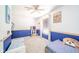A bright bedroom featuring blue accent wall, ceiling fan, and a sunny window at 5820 Marble Ct, Anderson, IN 46013