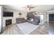 Open living room with hardwood floors, ceiling fan, fireplace, and comfortable couches at 5820 Marble Ct, Anderson, IN 46013