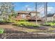 Landscaped backyard featuring yellow daffodils, a deck and brick exterior at 5861 Dawnwood Dr, Carmel, IN 46033