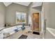 Spacious bathroom featuring a large tub under a window and a glass shower enclosure at 5861 Dawnwood Dr, Carmel, IN 46033
