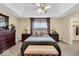 Cozy bedroom featuring a tray ceiling, neutral walls, and well-placed bedside lamps at 5861 Dawnwood Dr, Carmel, IN 46033
