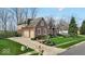 Brick and siding home features a two-car garage, driveway, and manicured lawn at 5861 Dawnwood Dr, Carmel, IN 46033