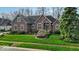 Lovely brick home features well-maintained lawn, mature landscaping, and charming architectural details at 5861 Dawnwood Dr, Carmel, IN 46033