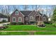 Charming brick home featuring manicured lawn and a well-designed garden bed at the front entrance at 5861 Dawnwood Dr, Carmel, IN 46033