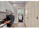 Home office with built-in storage, desk, and view to laundry room at 5861 Dawnwood Dr, Carmel, IN 46033