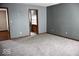 An interior view shows a spacious bedroom with gray carpeting and a glimpse into an attached bathroom at 607 Deer Trail Dr, Indianapolis, IN 46217