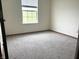 An interior shot shows a bedroom with neutral walls and flooring, along with a window that allows natural light at 607 Deer Trail Dr, Indianapolis, IN 46217