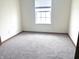 The bedroom features neutral walls, plush carpeting, and a bright window, creating a calming and comfortable space at 607 Deer Trail Dr, Indianapolis, IN 46217