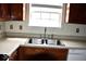 Kitchen sink with double basin, chrome faucet, light countertop, and wooden cabinets at 607 Deer Trail Dr, Indianapolis, IN 46217