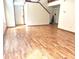 Bright living room featuring wood-look flooring, a staircase, and a welcoming front door at 607 Deer Trail Dr, Indianapolis, IN 46217