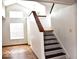 A staircase with wood-trimmed stairs, and a bright living room with hardwood floors at 607 Deer Trail Dr, Indianapolis, IN 46217