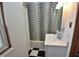 Bathroom featuring a shower/tub with polka dot shower curtain, storage cabinet, medicine cabinet, sink, and checkerboard flooring at 609 E Columbus St, Martinsville, IN 46151