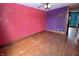 Bedroom with hardwood floors, red and purple walls with gold mandala design, and white trim at 609 E Columbus St, Martinsville, IN 46151