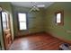 Comfortable bedroom with wooden floors, two windows, and a ceiling fan, offering natural light and ventilation at 609 E Columbus St, Martinsville, IN 46151