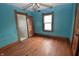 Comfortable bedroom boasts a ceiling fan, hardwood floors, and a bright window at 609 E Columbus St, Martinsville, IN 46151