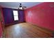 Bedroom featuring hardwood floors and red and purple walls with gold mandala designs at 609 E Columbus St, Martinsville, IN 46151