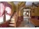 Welcoming entryway featuring hardwood staircase, bright window, and dining area, offering a charming first impression at 609 E Columbus St, Martinsville, IN 46151