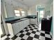 Kitchen with black and white checkered floors, black countertops, white cabinets, and turquoise walls at 609 E Columbus St, Martinsville, IN 46151