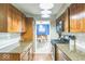 Kitchen with granite counters, wooden cabinets and stainless appliances leading to dining room at 6133 Buttonwood Dr, Noblesville, IN 46062