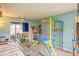 Colorful playroom with a climbing gym, slide, air hockey table, and view into dining room at 6133 Buttonwood Dr, Noblesville, IN 46062