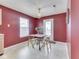 Eat-in kitchen featuring bright lighting, a tile tabletop and white appliances in red colored walls at 6212 Monteo Dr, Indianapolis, IN 46217