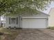 The home has a driveway, attached garage and a well maintained lawn with flower pots at 6212 Monteo Dr, Indianapolis, IN 46217