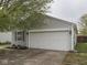 View of the garage door on a home with vinyl siding and a concrete driveway at 6212 Monteo Dr, Indianapolis, IN 46217