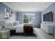 Cozy bedroom with a large window providing natural light, a television, and soft carpet at 6259 Bishops Pond Ln, Indianapolis, IN 46268