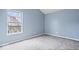 Well-lit carpeted bedroom with a large window offering outdoor views at 6259 Bishops Pond Ln, Indianapolis, IN 46268