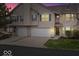 Two-story home featuring a two-car garage, neutral siding and trim, a well maintained lawn, and manicured bushes at 6259 Bishops Pond Ln, Indianapolis, IN 46268