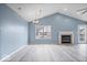 Bright living room with a vaulted ceiling, fireplace, ceiling fan, hardwood floors, and natural light at 6259 Bishops Pond Ln, Indianapolis, IN 46268