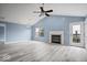Bright living room with a vaulted ceiling, fireplace, ceiling fan, hardwood floors, and natural light at 6259 Bishops Pond Ln, Indianapolis, IN 46268