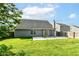 The well-kept backyard features a patio, a pergola, lush grass, and the house with sliding glass doors at 6479 Enclave Blvd, Greenwood, IN 46143