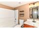 A tidy bathroom featuring a shower-tub combo, single sink vanity, and sleek shelving for optimal storage at 6479 Enclave Blvd, Greenwood, IN 46143