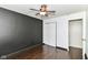 Well-lit bedroom with wood floors, ceiling fan, closet, and a designer accent wall at 6479 Enclave Blvd, Greenwood, IN 46143