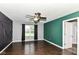 Modern bedroom with dark wood floors, a ceiling fan, and an accent wall at 6479 Enclave Blvd, Greenwood, IN 46143