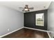 Bedroom with dark floors, ceiling fan, natural light, and a modern accent wall at 6479 Enclave Blvd, Greenwood, IN 46143
