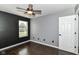 Comfortable bedroom featuring a ceiling fan, wood flooring, and a modern accent wall at 6479 Enclave Blvd, Greenwood, IN 46143