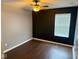 Cozy bedroom with wood floors, ceiling fan and a dark accent wall at 6479 Enclave Blvd, Greenwood, IN 46143