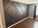 Bedroom featuring dark accent wall with geometric design and hardwood floors at 6479 Enclave Blvd, Greenwood, IN 46143